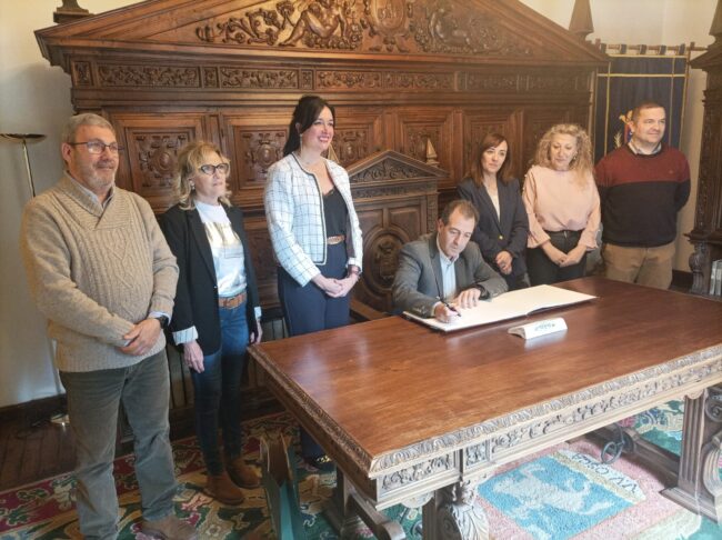 Carmelo Pérez firma en el Libro de Honor de Huesca.